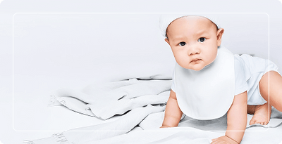 Baby wearing a bib on a white blanket