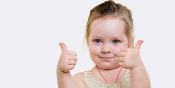 Child giving a thumbs-up gesture on a white background
