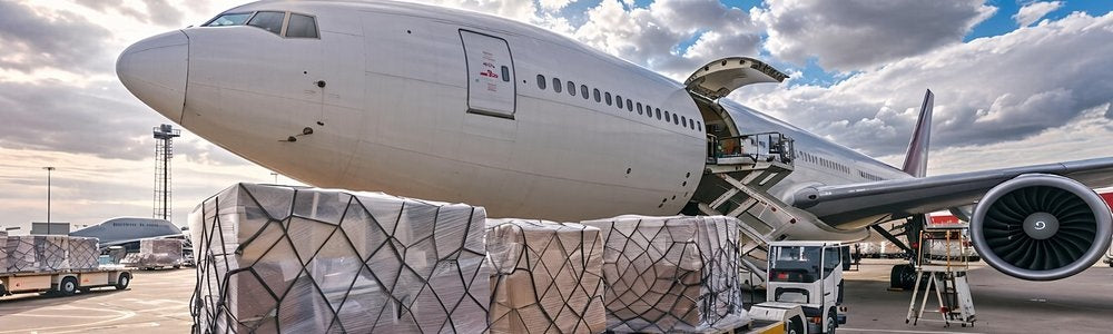 Cargo plane being loaded with wrapped pallets for free express shipping of European baby formula to the U.S. in 2 to 4 business days
